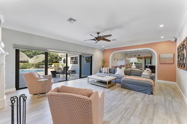 living room featuring ornamental molding, a wealth of natural light, ceiling fan, and light hardwood / wood-style floors