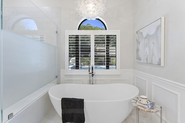 bathroom with a bath and a chandelier