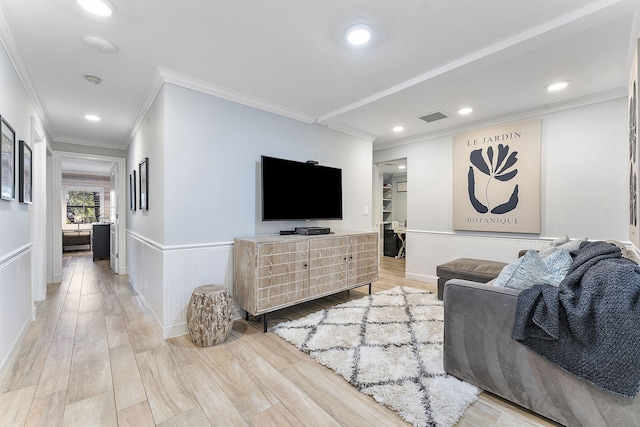 living room with wood-type flooring and ornamental molding