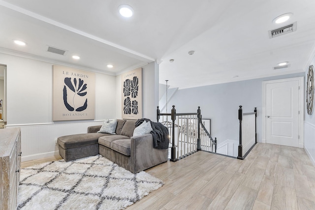 living room featuring crown molding and light hardwood / wood-style flooring