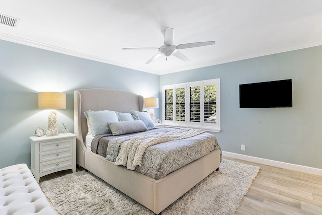 bedroom featuring ceiling fan, ornamental molding, and light hardwood / wood-style flooring