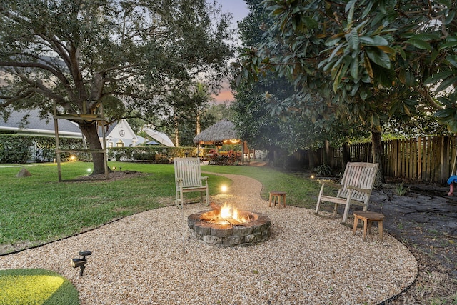 yard at dusk with a gazebo and an outdoor fire pit