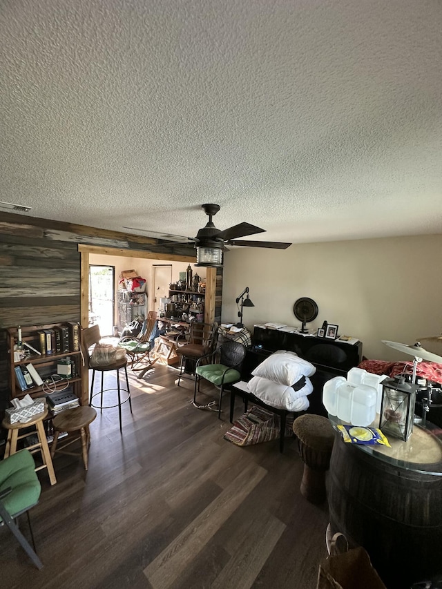 sitting room featuring hardwood / wood-style flooring, ceiling fan, and a textured ceiling