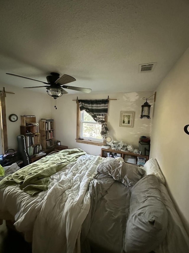 bedroom featuring ceiling fan and a textured ceiling