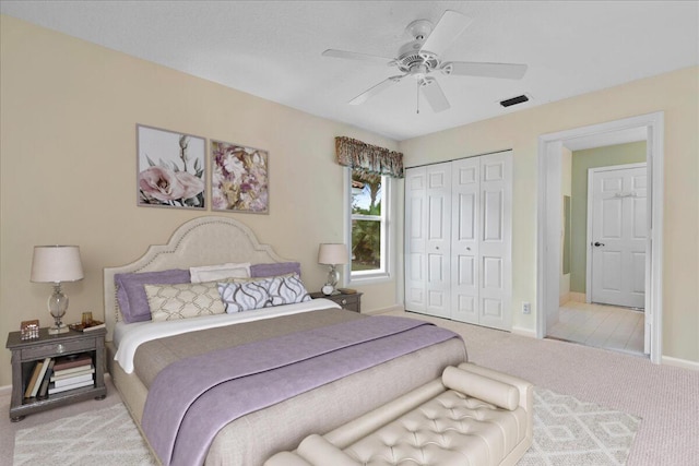 carpeted bedroom with ceiling fan and a closet