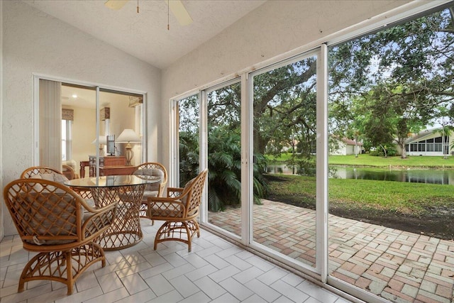 sunroom / solarium featuring a water view, ceiling fan, and lofted ceiling