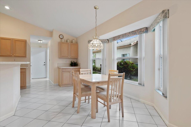 dining area featuring vaulted ceiling and light tile patterned floors