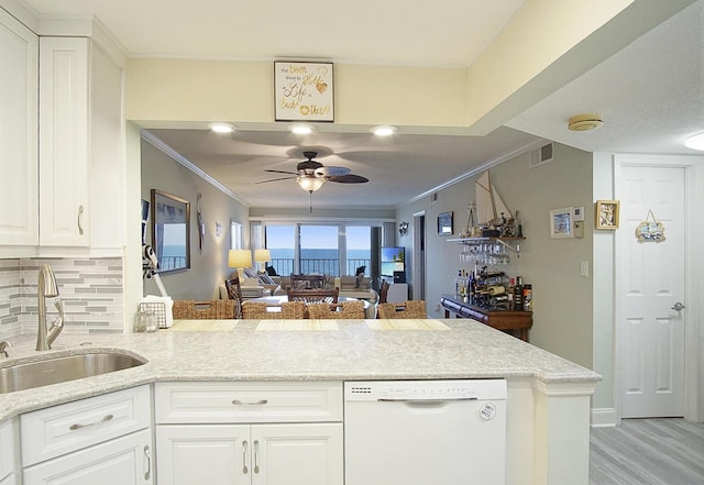 kitchen featuring sink, white cabinetry, crown molding, dishwasher, and kitchen peninsula