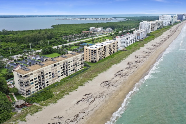 drone / aerial view featuring a water view and a view of the beach