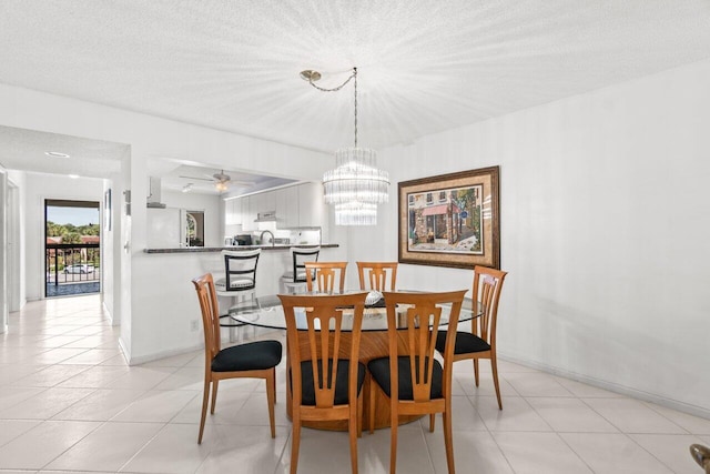 dining room featuring ceiling fan with notable chandelier, light tile patterned floors, and a textured ceiling