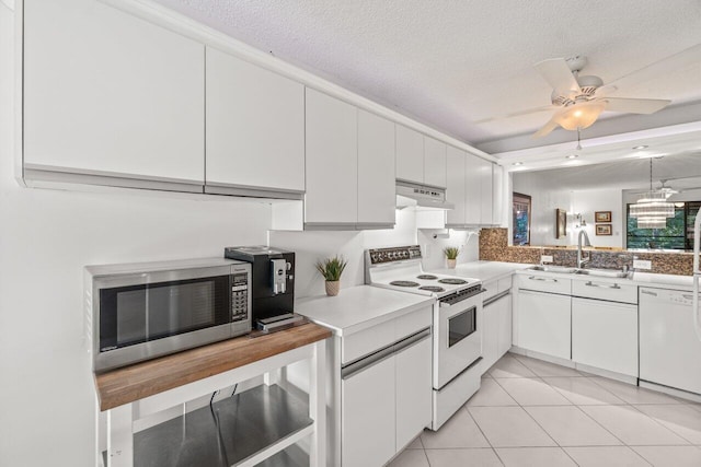 kitchen with white cabinetry, sink, white appliances, and a textured ceiling