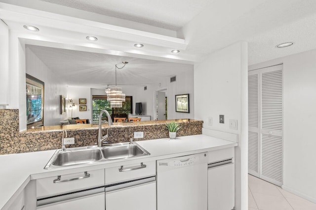 kitchen with light tile patterned flooring, white cabinetry, dishwasher, sink, and a textured ceiling