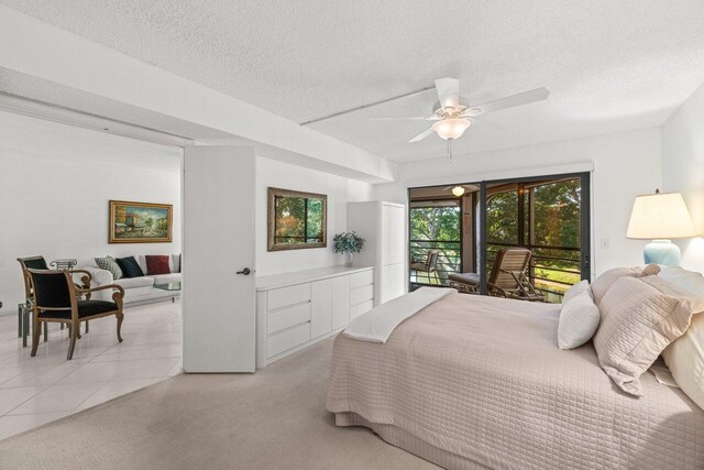 carpeted bedroom featuring ceiling fan, access to exterior, and a textured ceiling