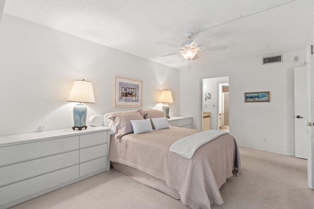 carpeted bedroom with connected bathroom, ceiling fan, and a textured ceiling