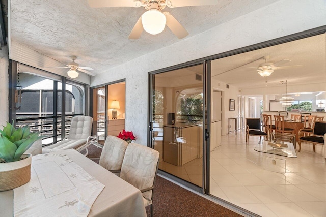 dining space with ceiling fan, a textured ceiling, and light tile patterned floors