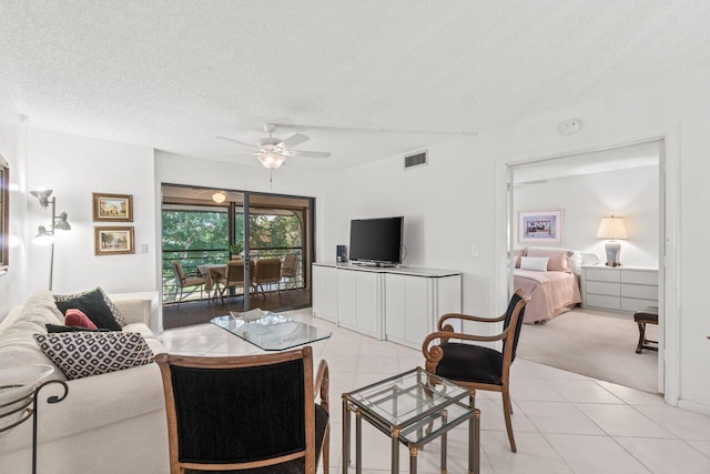 tiled living room with ceiling fan and a textured ceiling