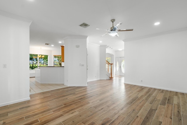 unfurnished living room featuring ceiling fan with notable chandelier, ornamental molding, and light wood-type flooring