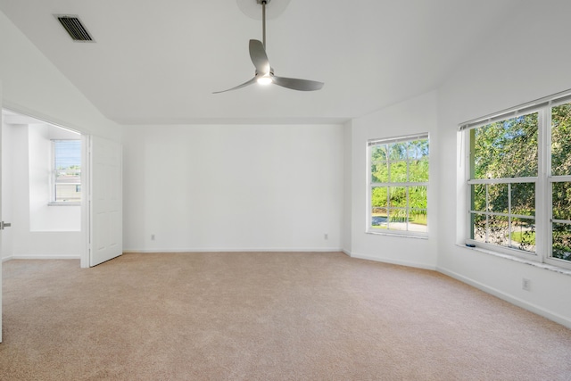 spare room featuring lofted ceiling, light colored carpet, and ceiling fan