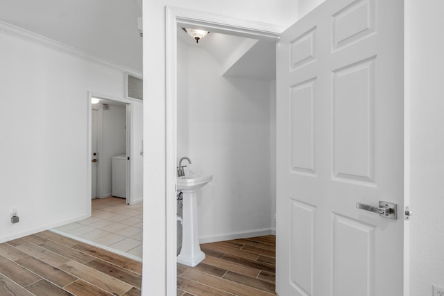 bathroom with ornamental molding and washer / dryer