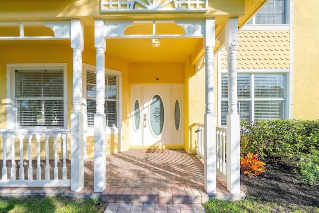 view of exterior entry featuring covered porch