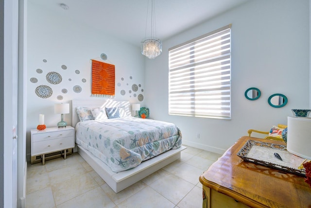 bedroom featuring light tile patterned floors and a chandelier