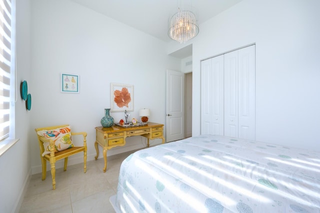 tiled bedroom featuring an inviting chandelier and a closet