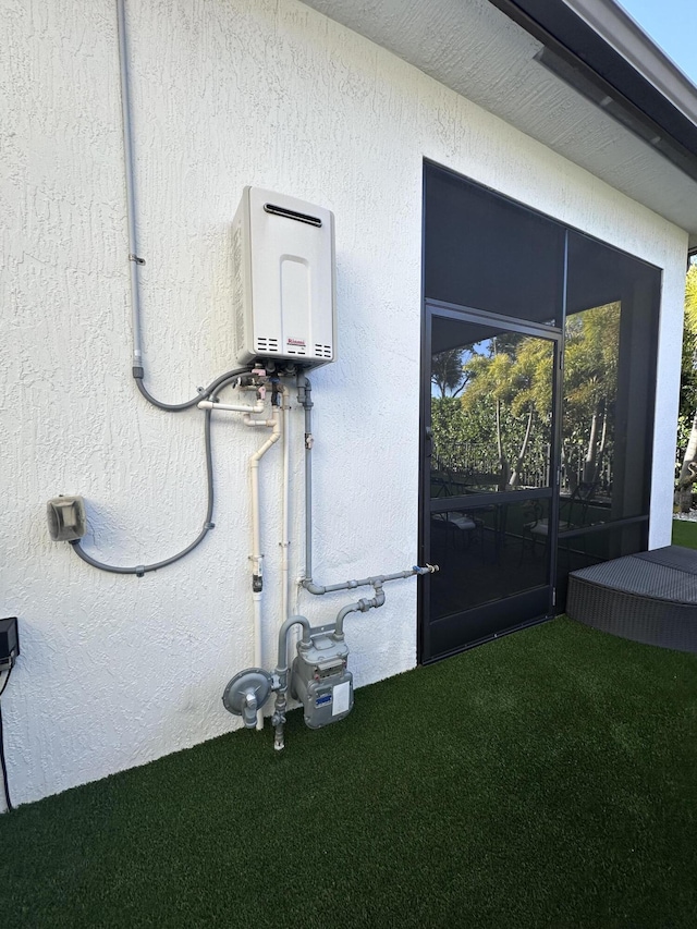 view of side of home featuring water heater and a lawn