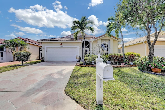 mediterranean / spanish house featuring a garage and a front yard