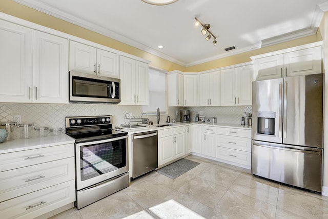 kitchen with white cabinetry, sink, backsplash, ornamental molding, and stainless steel appliances