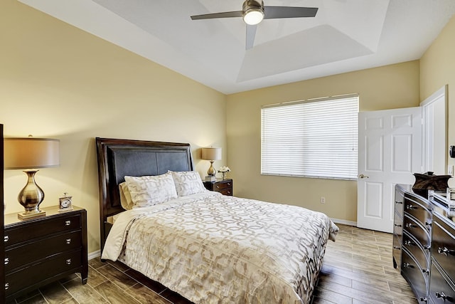 bedroom with a raised ceiling and ceiling fan