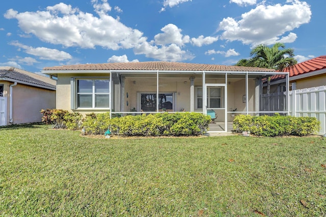 back of property with a sunroom and a yard