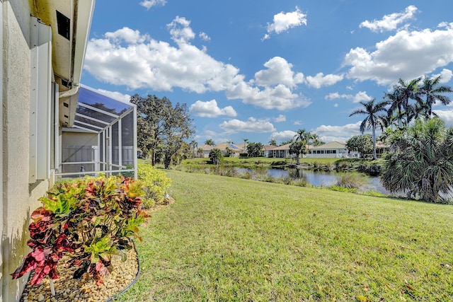 view of yard featuring a water view and glass enclosure