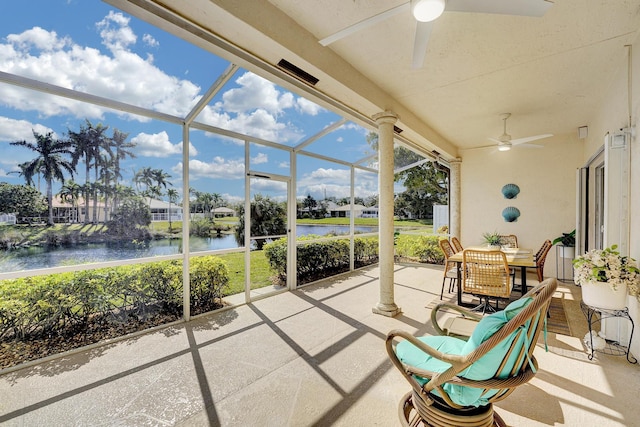 sunroom / solarium featuring a water view and ceiling fan