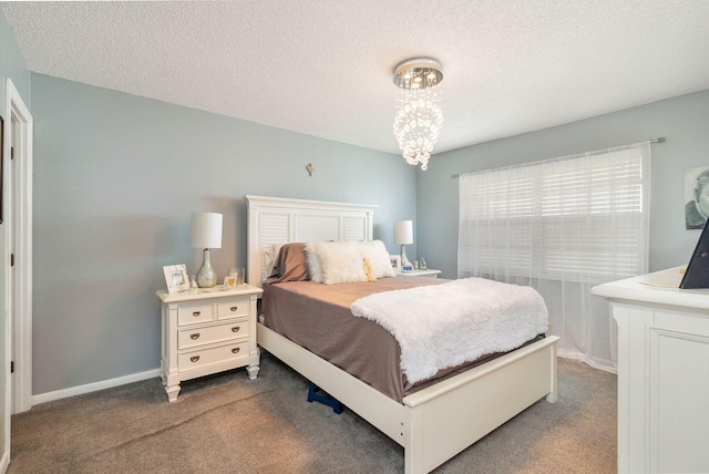 carpeted bedroom featuring a textured ceiling and an inviting chandelier