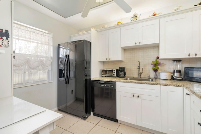 kitchen featuring tasteful backsplash, sink, white cabinets, black appliances, and light stone countertops