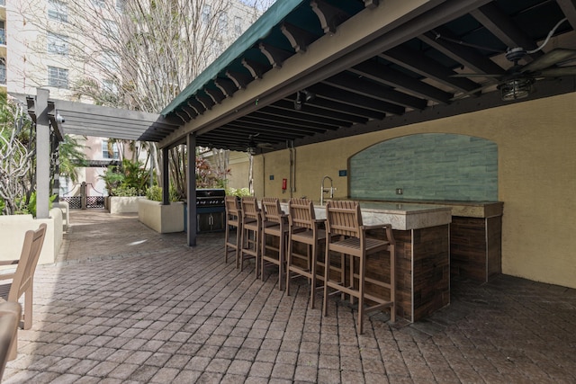 view of patio / terrace featuring ceiling fan, a pergola, and an outdoor wet bar