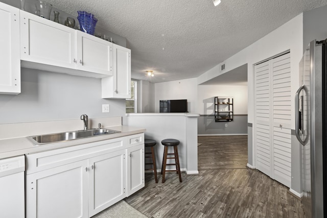 kitchen with sink, white cabinetry, stainless steel fridge, dishwasher, and kitchen peninsula