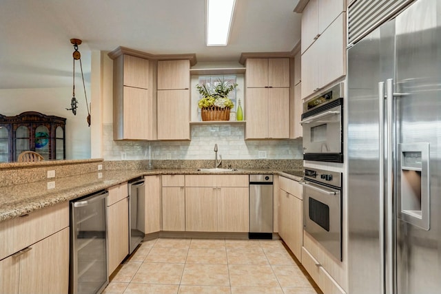 kitchen with sink, stainless steel built in refrigerator, wine cooler, light stone counters, and light brown cabinets