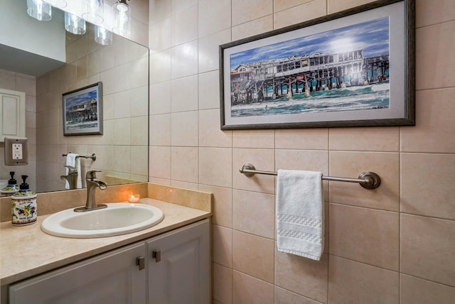 bathroom featuring vanity and tile walls