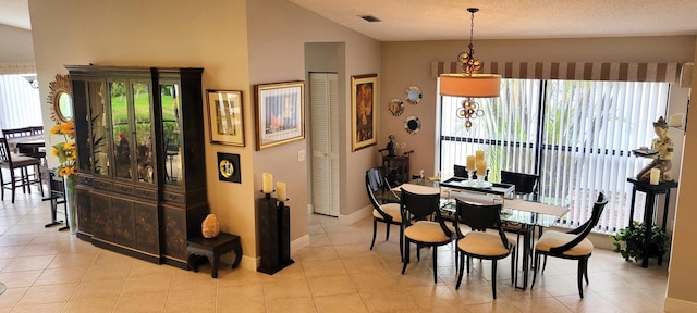 tiled dining area with lofted ceiling, plenty of natural light, and a textured ceiling