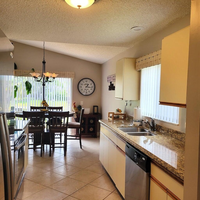 kitchen with vaulted ceiling, light tile patterned flooring, sink, hanging light fixtures, and stainless steel appliances