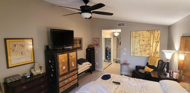 bedroom with ceiling fan, wood-type flooring, vaulted ceiling, and a textured ceiling