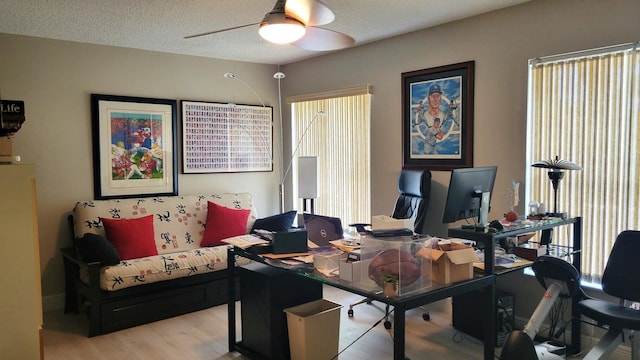 office area with a textured ceiling, light hardwood / wood-style floors, and ceiling fan