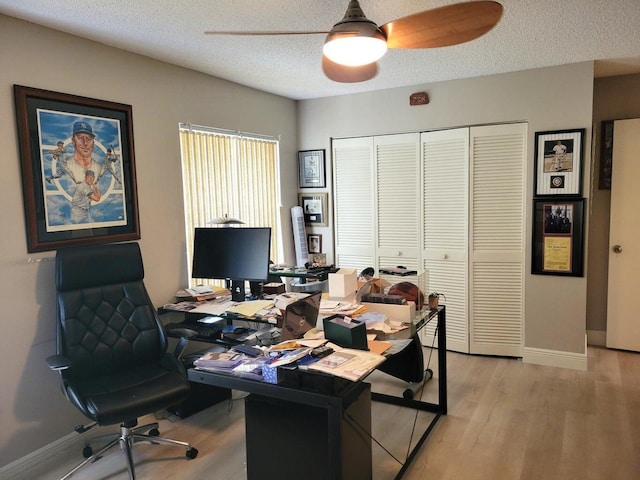 office featuring ceiling fan, light hardwood / wood-style floors, and a textured ceiling