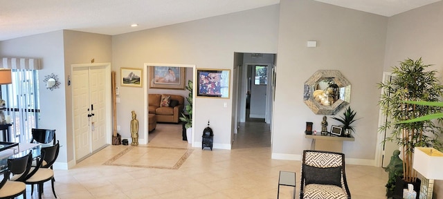 entryway with lofted ceiling and light tile patterned floors