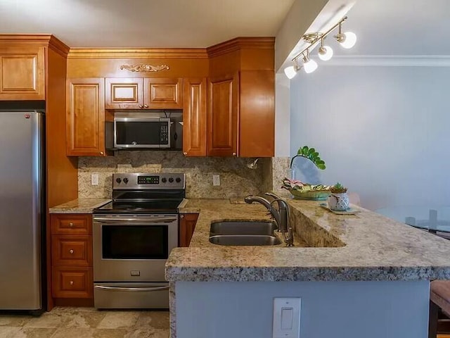 kitchen with appliances with stainless steel finishes, kitchen peninsula, sink, and backsplash