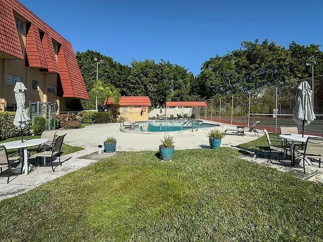 view of pool with a yard and tennis court