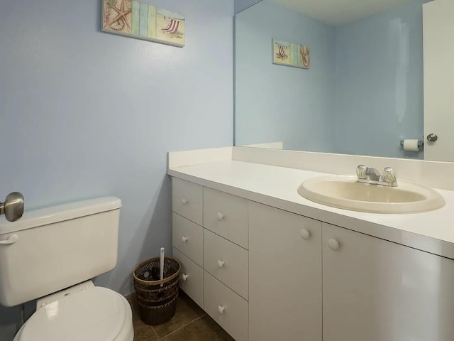 bathroom with tile patterned flooring, vanity, and toilet