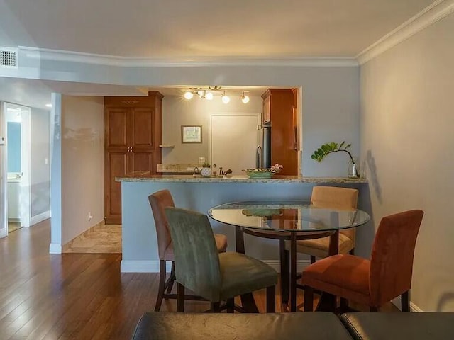 dining space with crown molding and wood-type flooring