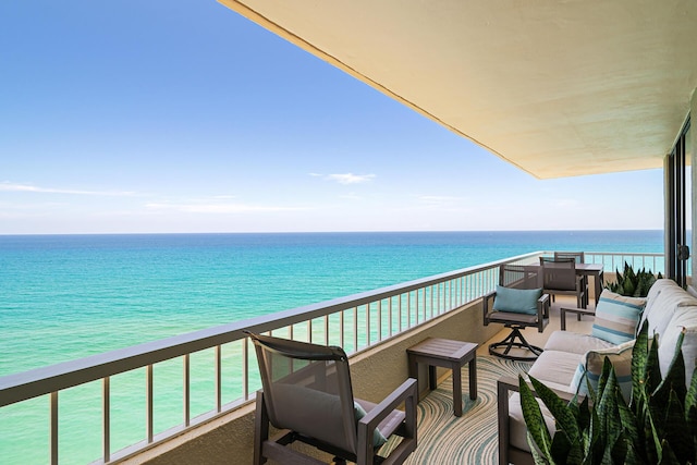 balcony with a water view and an outdoor living space